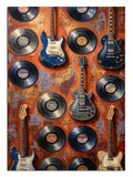 Duvarda asılı duran vinil plaklar ve gitarlardan oluşan koleksiyon.